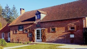 A brick building with a tiled roof, a central entrance, and a sign indicating it is a restaurant. - Auberge de villechaume (Sennely)