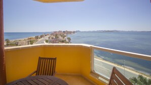 Un balcon avec vue sur la mer et une ville côtière.