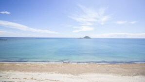 A beach with clear blue water and a distant island. - Superb penthouse perfectly located just steps from the beach... (La Manga del Mar Menor)