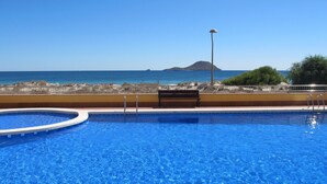 A swimming pool with a view of the sea and a distant island. - Superb penthouse perfectly located just steps from the beach... (La Manga del Mar Menor)