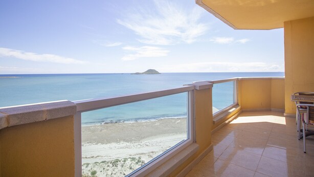 A balcony with a view of the sea and a distant island. - Superb penthouse perfectly located just steps from the beach... (La Manga del Mar Menor)