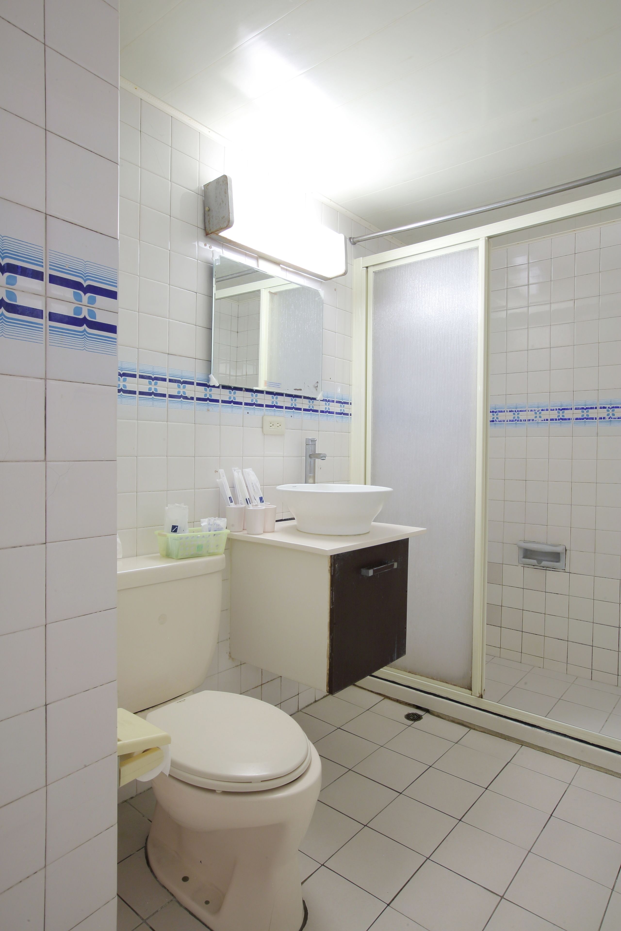 A bathroom with a toilet, sink, and shower.