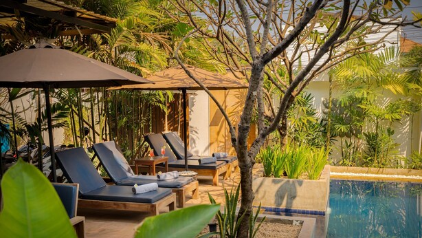 A poolside area with lounge chairs, umbrellas, and a small pool. - Landing Zone Boutique Hotel (Siem Reap)