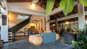 A spacious indoor area with a staircase, wicker furniture, and a reception desk. - Landing Zone Boutique Hotel (Siem Reap)