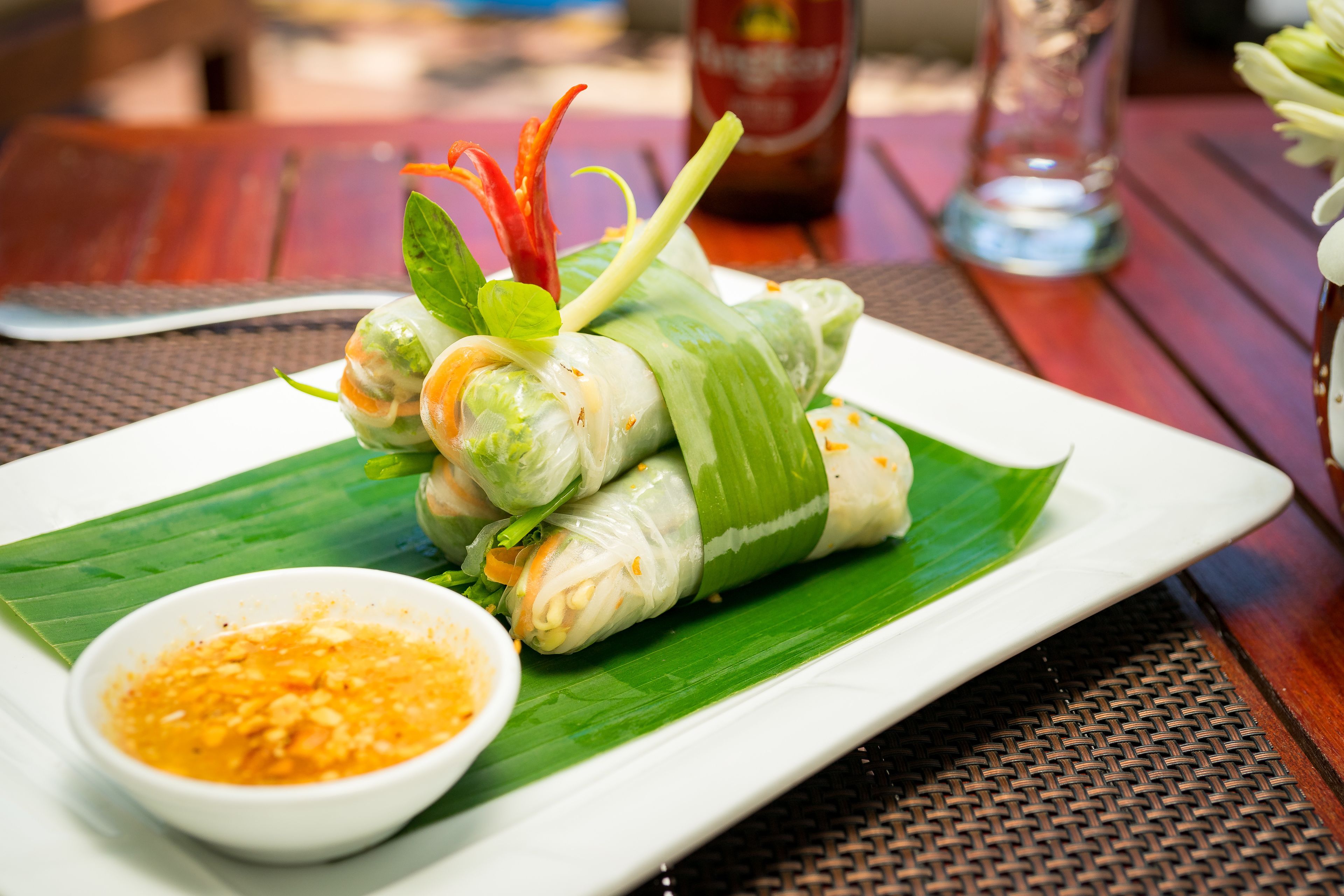 Une assiette de rouleaux de printemps vietnamiens, accompagnés d’une sauce pour tremper.