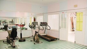 Une salle de sport à domicile équipée d’un tapis de course, d’un vélo d’appartement et d’un appareil de musculation elliptique.