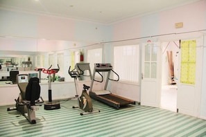 A home gym with a treadmill, stationary bike, and elliptical machine.