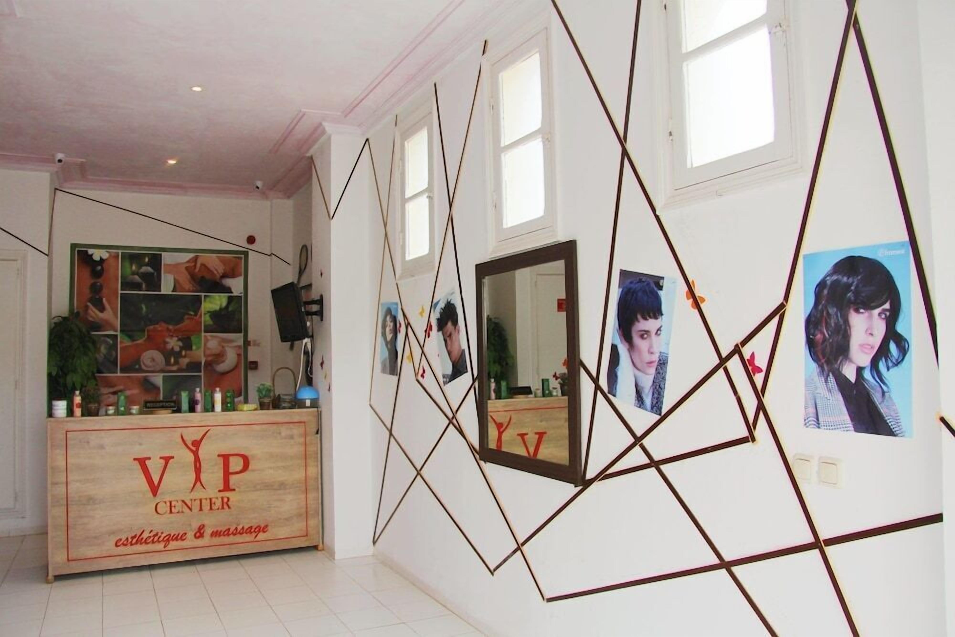 A spa center interior with a reception desk, framed artwork, and geometric wall decorations.