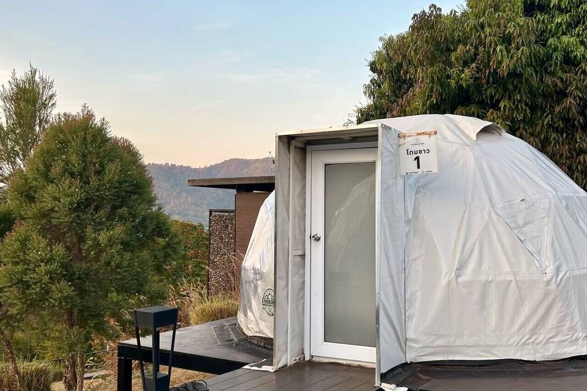 A small, enclosed tent with a door, a wooden deck, and a table.