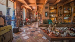 A rustic interior with exposed brick walls, wooden beams, and a checkered floor.