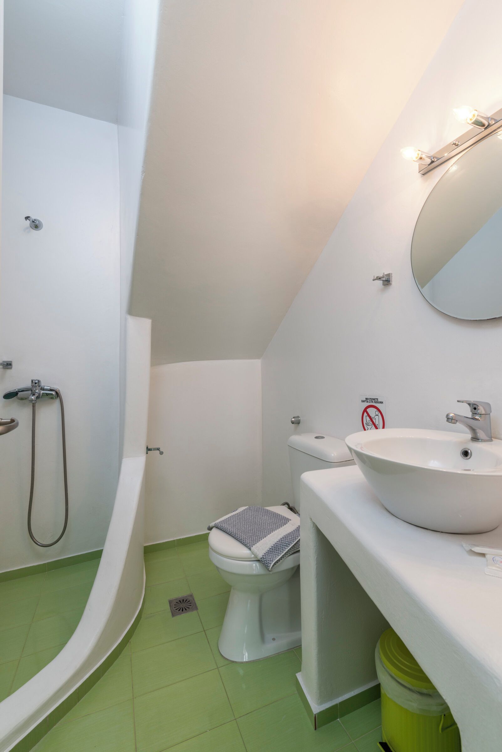 A bathroom with a toilet, sink, and shower.