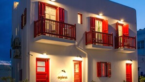A two-story building with red-framed windows and balconies, featuring a sign that reads "orphreas." - Orpheas Rooms (Mykonos)