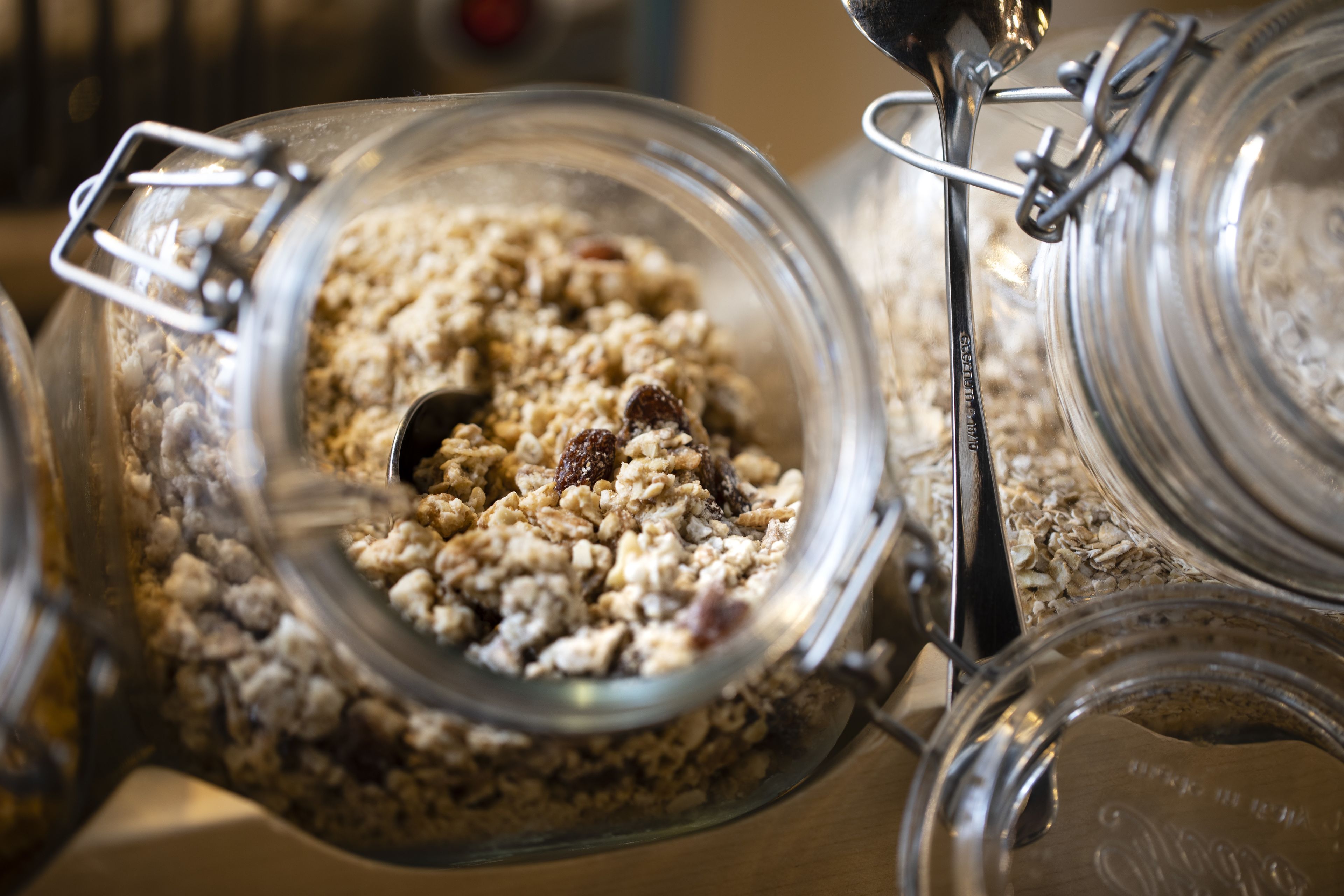 A glass jar filled with granola and nuts.