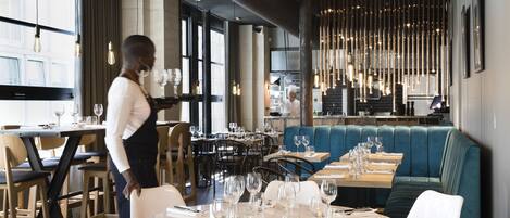 Un interior de restaurante con mesas dispuestas para comer, una zona de bar y un área de estar.