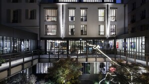 Un immeuble à plusieurs étages doté de grandes fenêtres et d’un atrium central.