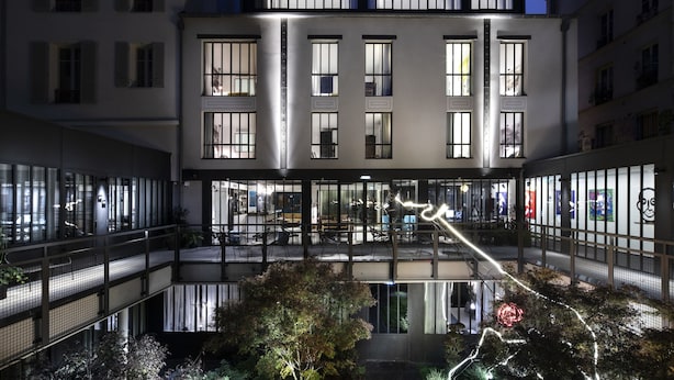 Un immeuble à plusieurs étages doté de grandes fenêtres et d’un atrium central.