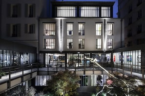 Un edificio de varios pisos con grandes ventanales y un atrio central.