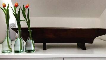 Three glass vases with tulips on a white shelf.