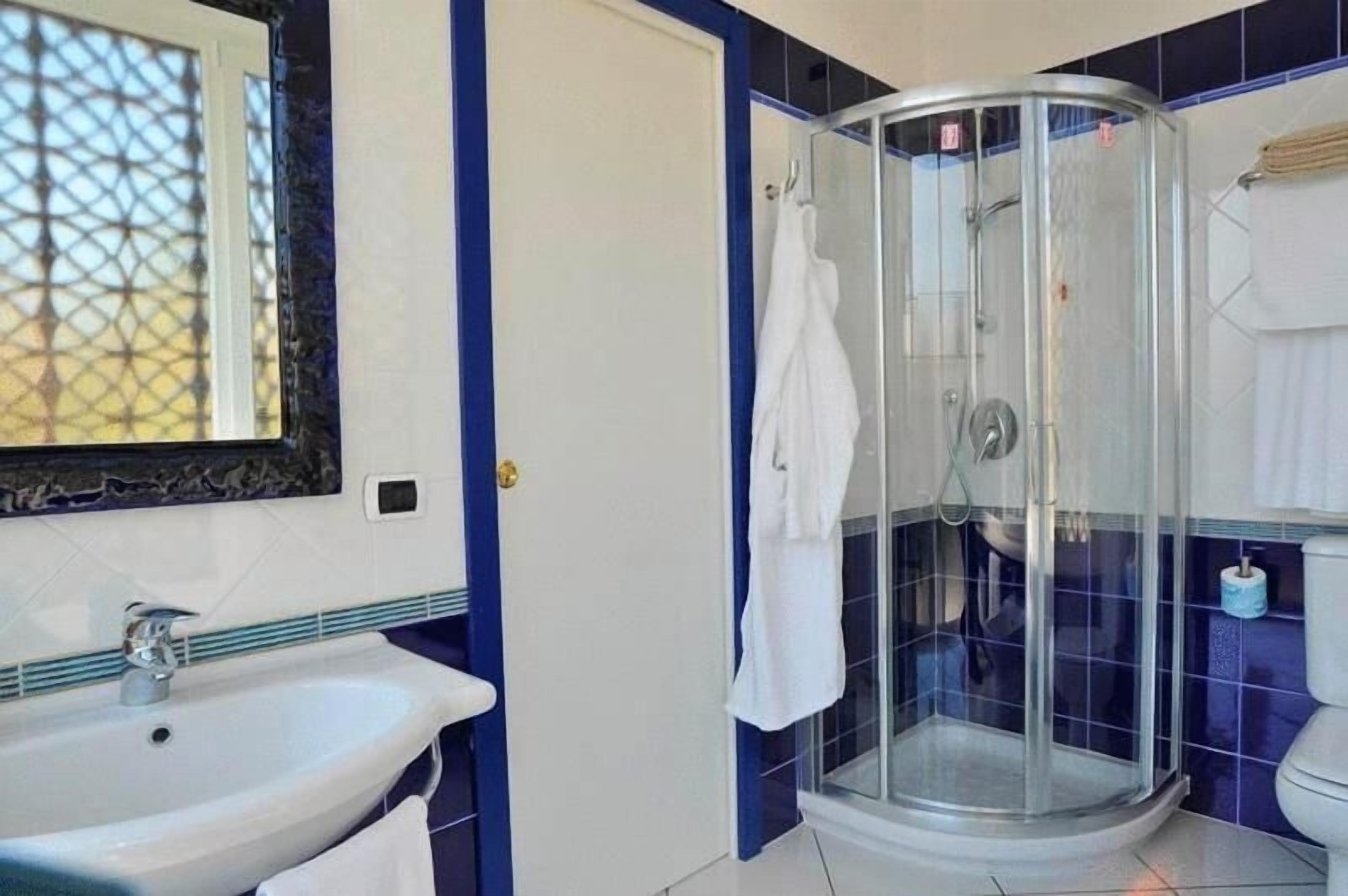 Une salle de bain avec une douche à parois de verre, un lavabo et des toilettes.