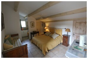 Een slaapkamer met een bed, nachtkastjes, een lamp en een raam.