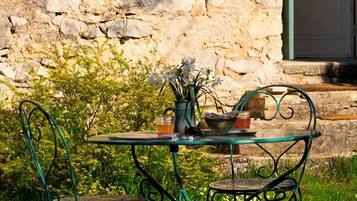A stone building with a metal table and chairs outside.