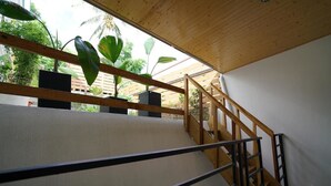 Una escalera de madera con barandillas de metal que lleva a un nivel superior.