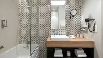 A modern bathroom with a glass-enclosed shower, a wooden vanity with a sink, and a mirror above it.