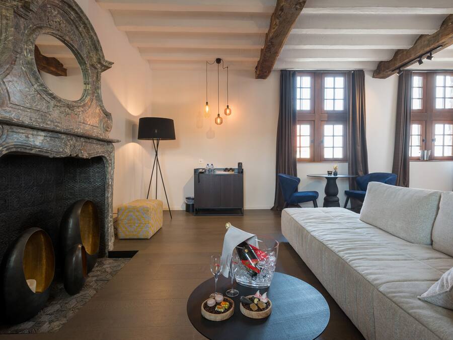 Een moderne woonkamer met een open haard, een bank, een eettafel en een keuken.