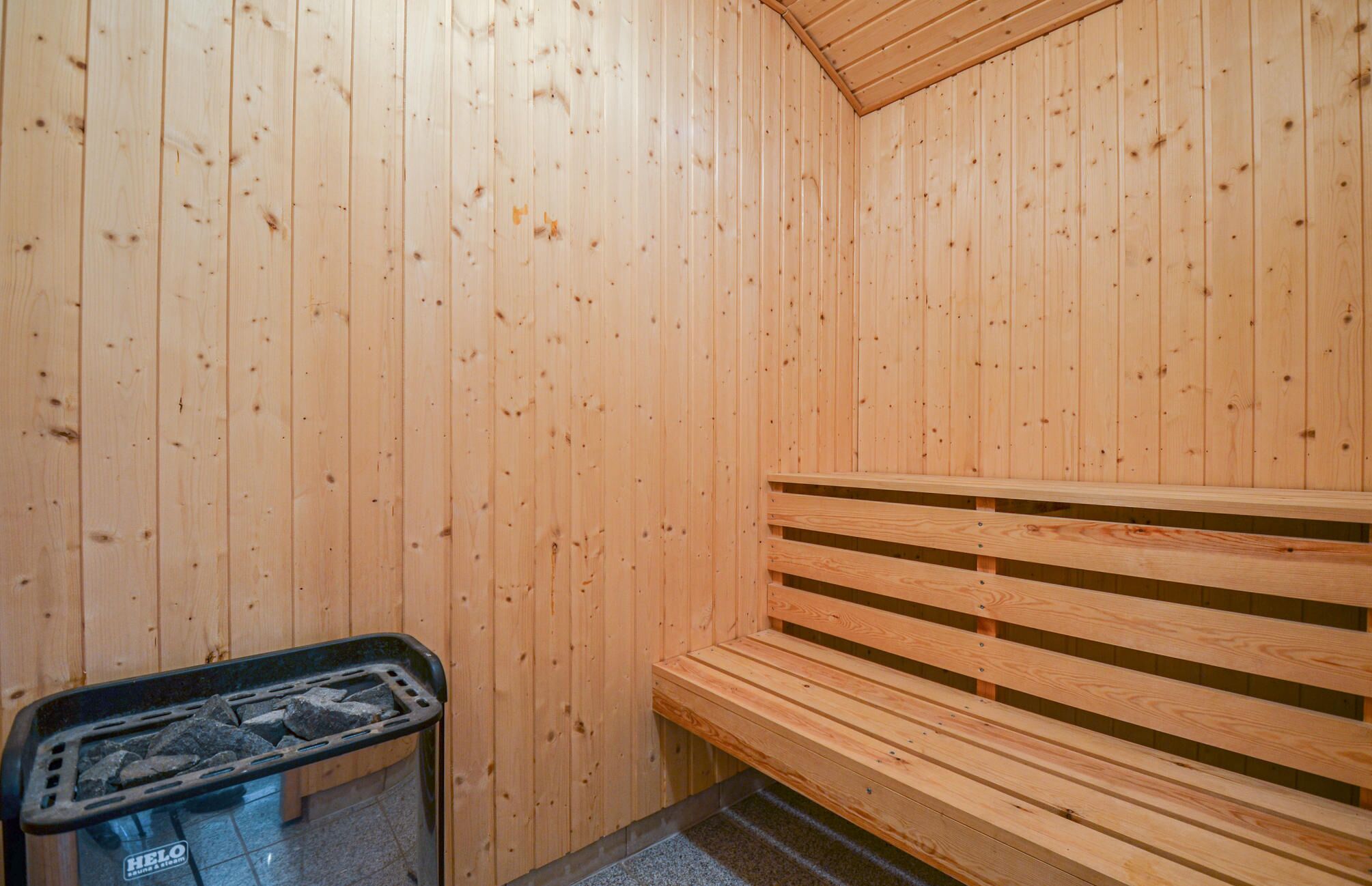 Et sauna rum med trævægge og en bænk.