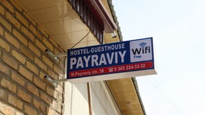 Letrero de un hostal que anuncia WiFi gratuito e información de contacto.