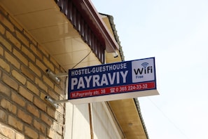 A hostel sign advertising free WiFi and contact information.