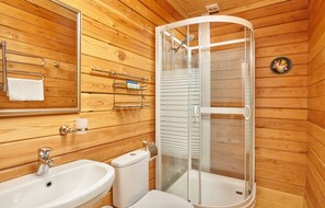 A wooden-paneled bathroom with a sink, toilet, and glass-enclosed shower. - Bogdarnya Hotel by KEYDOM (Krutovo)