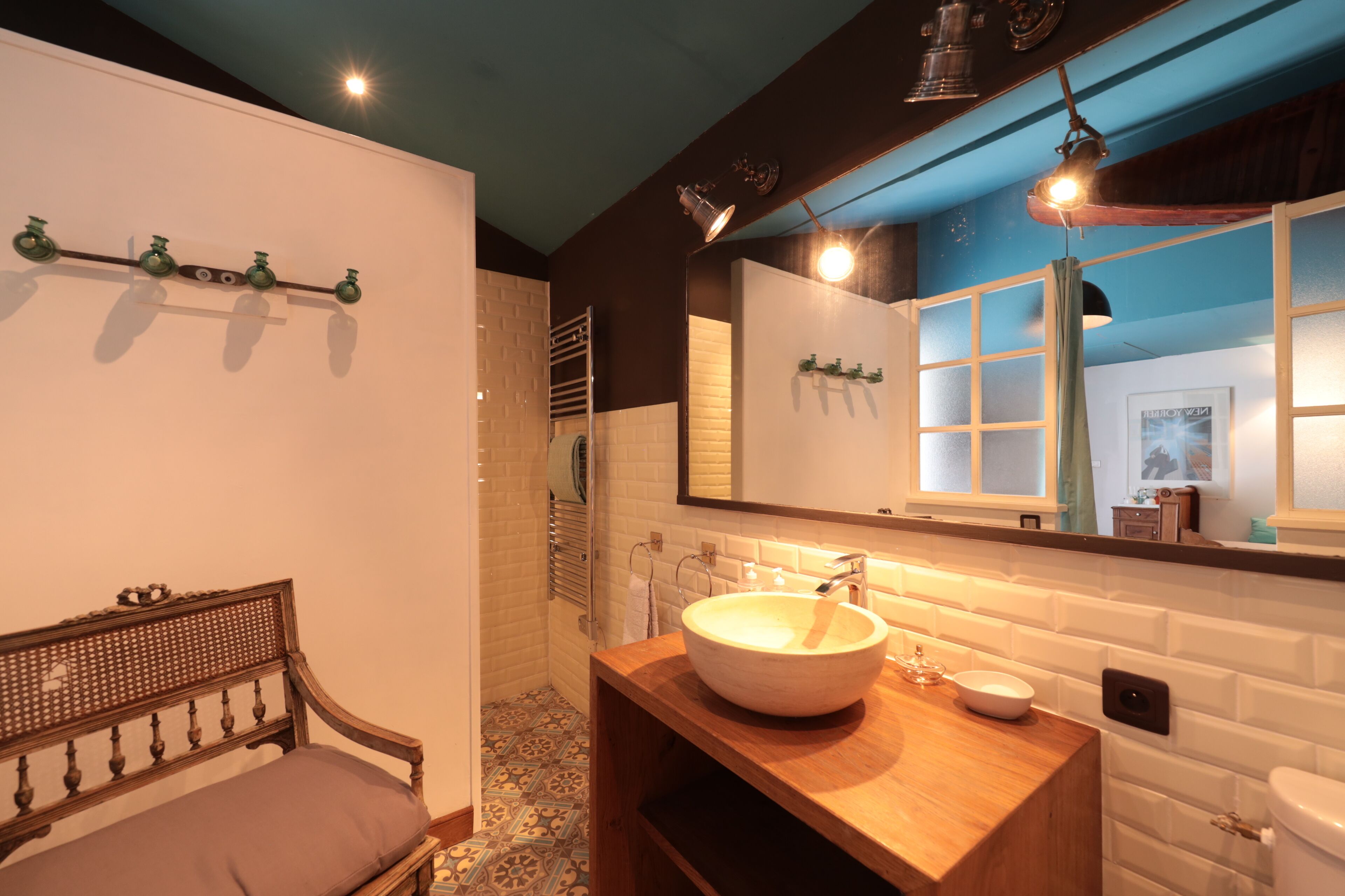 A bathroom with a wooden vanity, a large mirror, and a white sink.