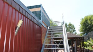 Un bâtiment rouge avec un escalier métallique menant à un balcon.