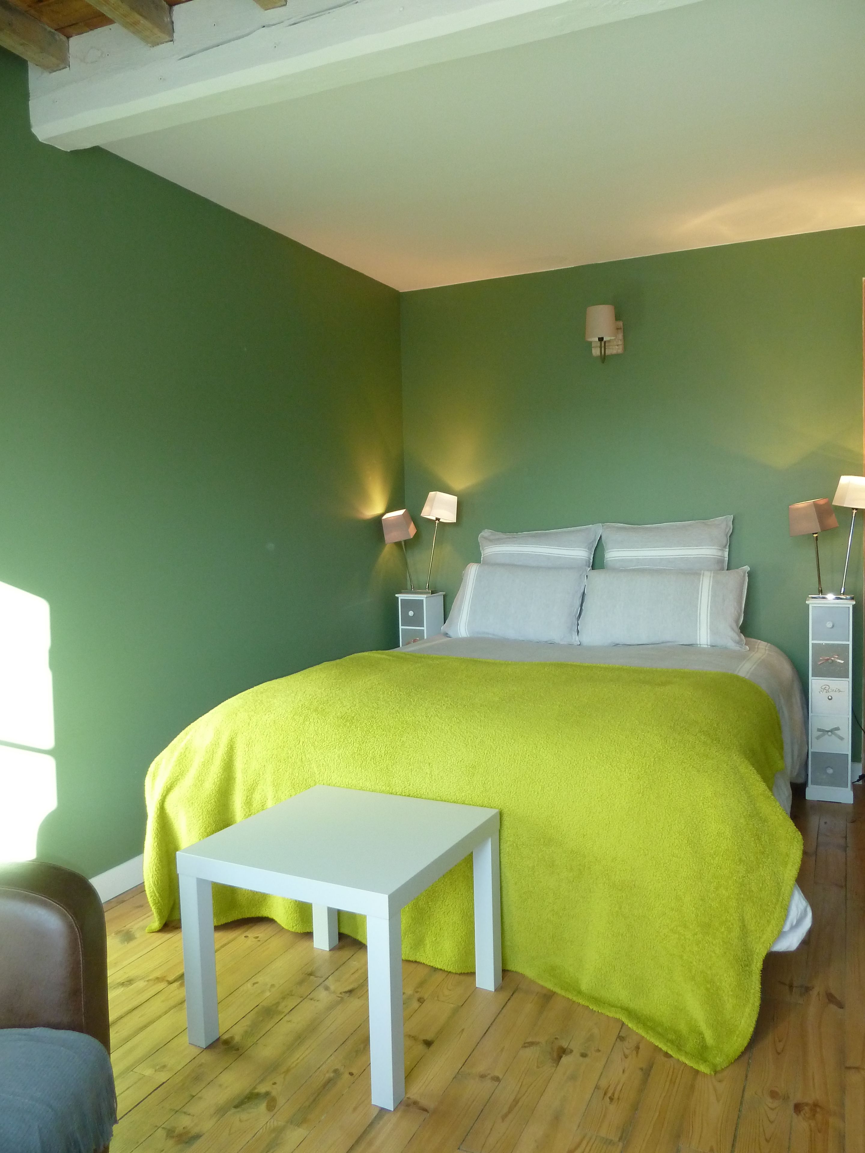 Ein Schlafzimmer mit einem Bett, einem Nachttisch und zwei Wandleuchten.