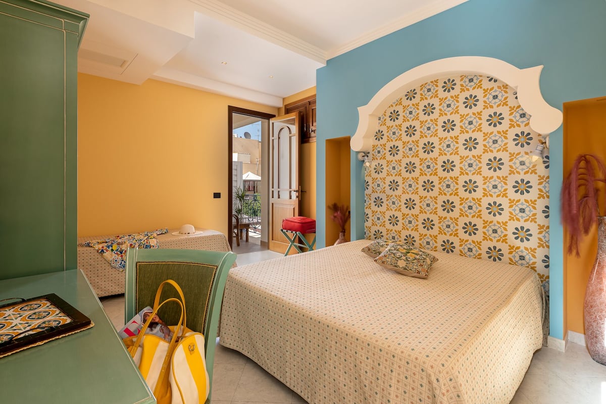 Un dormitorio con cama, una silla, una mesa y un armario.