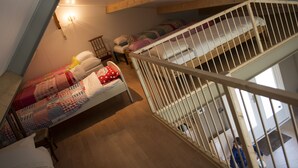 A dormitory-style room with bunk beds, a staircase, and a chandelier. - B&B Logeren bij van Heeren (Made)