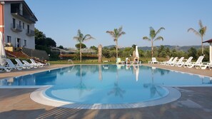 Una piscina al aire libre, tumbonas