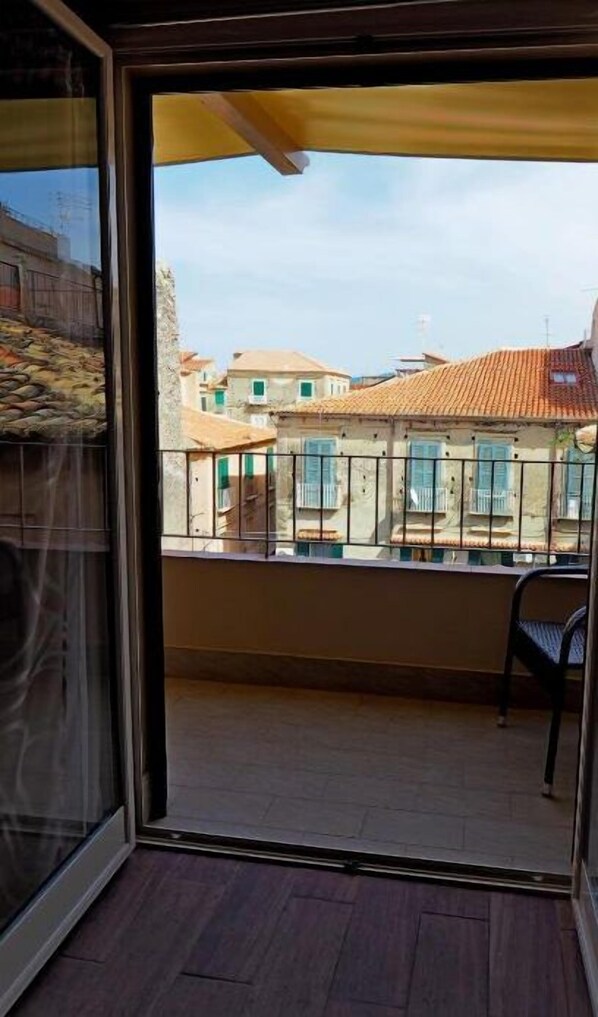 A balcony with a view of traditional buildings and a tiled roof. - Residenza LoryLu (Tropea)