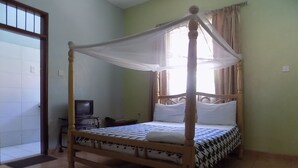 A four-poster bed with a canopy, a television on a stand, and a tiled floor. - Etana Motel (Kampala)