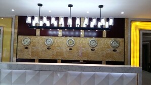 A reception desk with a marble top and multiple clocks. - Kololo Courts Hotel & Restaurant (Kampala)