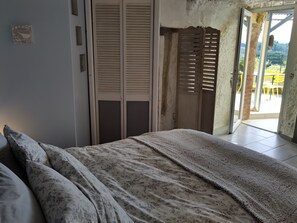 Un dormitorio con una cama, un armario de madera y un puerta corredera que da a un balcón.