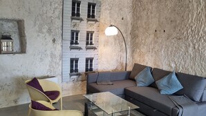 Un salon avec un canapé, un fauteuil et une table basse en verre.