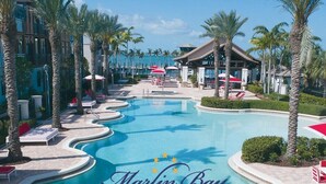 A resort pool with palm trees, lounge chairs, and umbrellas. - Pet & Family Friendly, Sleeps 8 - Marlin Bay (Marathon)