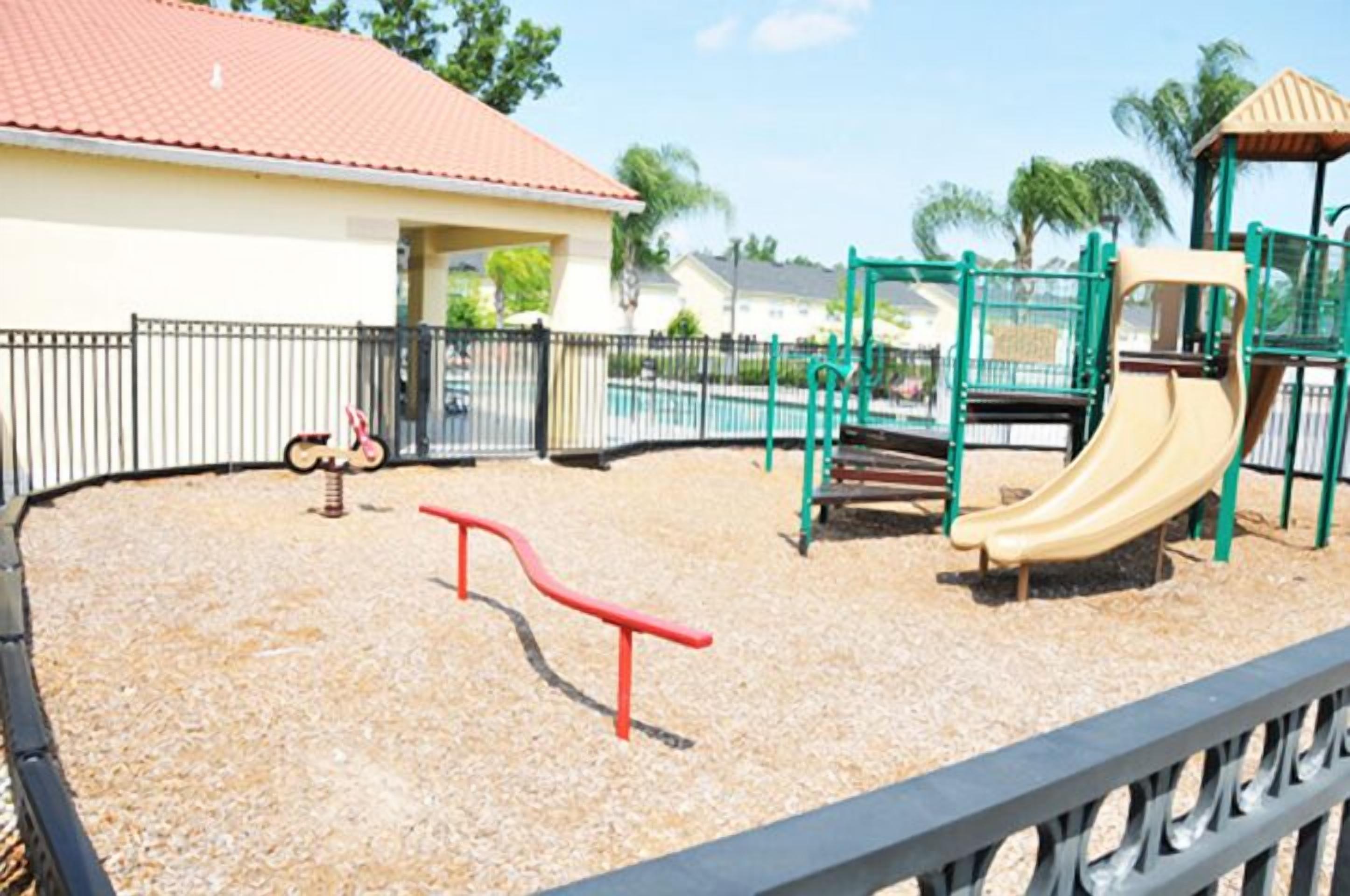 Un parque infantil con tobogán, estructuras para escalar y columpios.