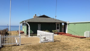 A small, single-story house with a green exterior and a white porch. - Cottage by the Sea - Ocean Front (Yachats)