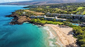 Um resort costeiro com acomodações na praia, campo de golfe e vista para o oceano.