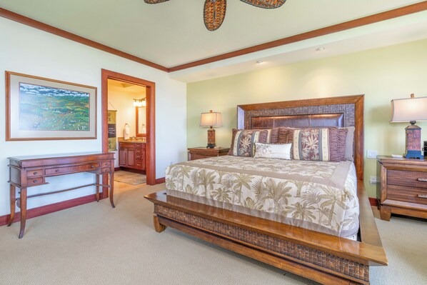 A bedroom with a large bed, a desk, and a chair. - Spacious Condo with Backyard and Ocean views | Mauna Kea Resort (Kamuela)