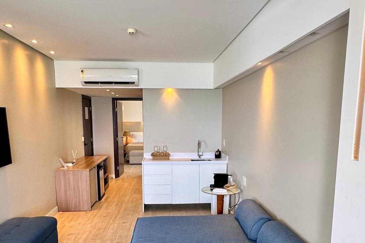 A compact living space with a kitchenette, a sofa, and a dining area.