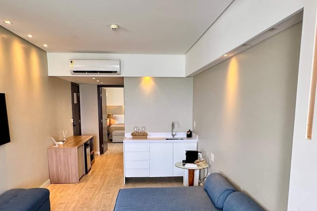 Un espacio habitable compacto con kitchenette, un sofá y una zona de comedor.